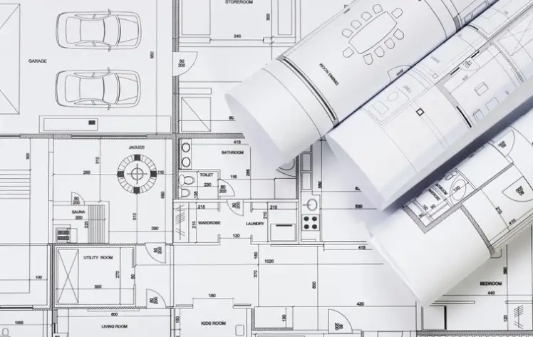 “Custom home floor plan blueprints with rolled architectural drawings, showing home design planning and layout details.”